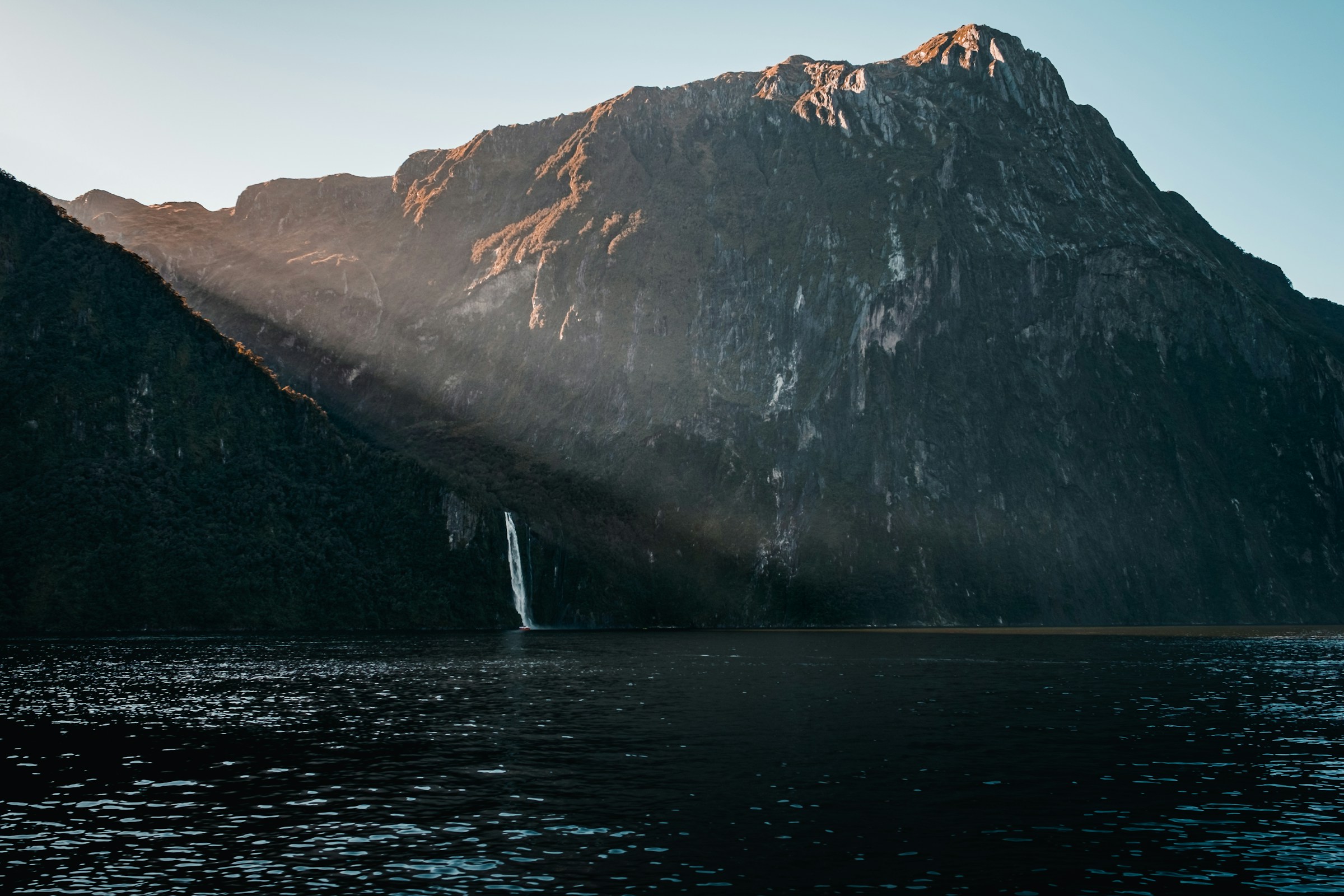 Montañas y una cascada sobre las aguas de Milford Sound